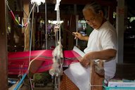 A person weaving silk at a loom, Ban Tha Sawang, Surin Province, Thailand